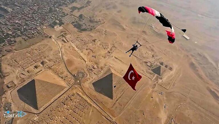 A paratrooper flies with the Turkish flag over the pyramids of Egypt